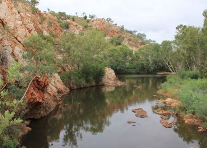 Paroo Waterhole with orange and white cliffs on the left of the water