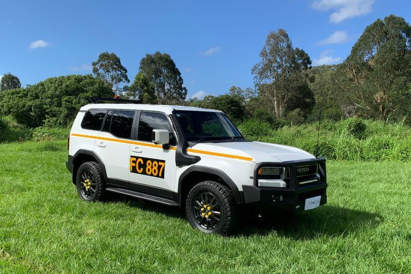 white mine-spec landcruiser prado 250 series parked on the grass