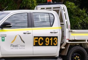 Orange call sign on a black background on the back door of a white ute