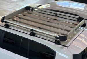Silver roof racks installed on top of a white Landcruiser