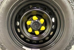 Yellow plastic wheel nut indicator caps covering the nuts of a wheel