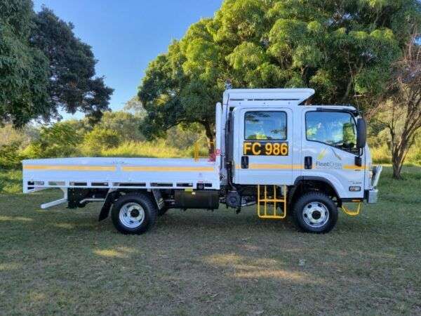 Side on view of a mine spec Isuzu tray back truck